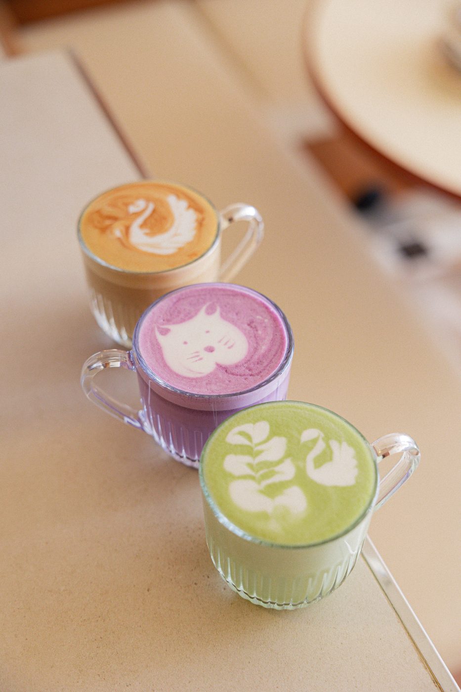 Trois latte art DOM : café, matcha et boisson violette